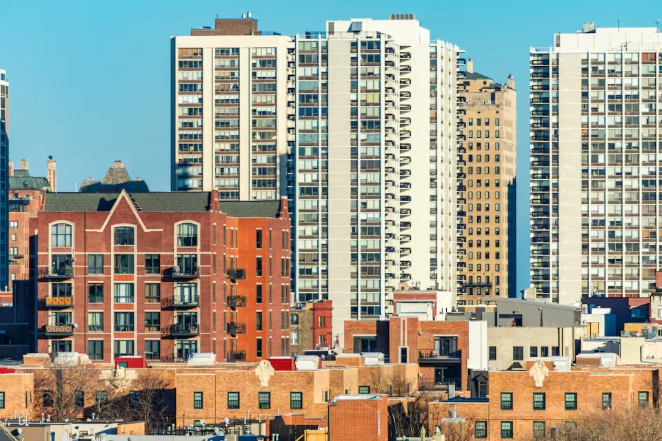 View of Chicago Old Town neighborhood with low-rise brick buildings in foreground and tall residential high-rises in background.